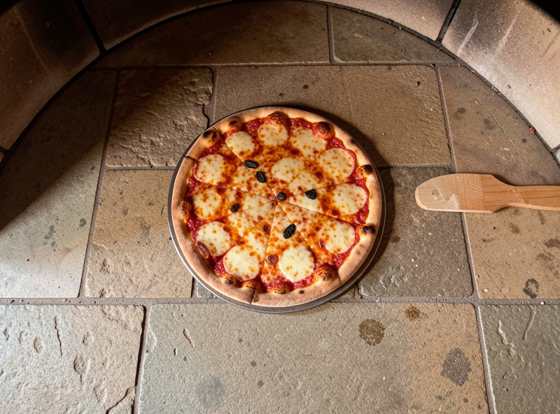 A 16-inch pizza fitting comfortably inside a pizza oven with room for a turning peel